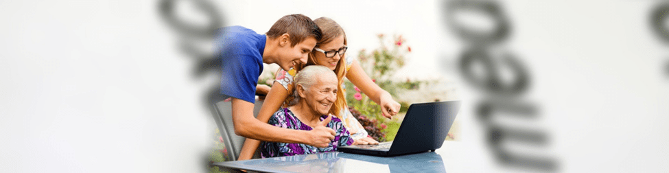 A group of people sitting around a table with a laptop.